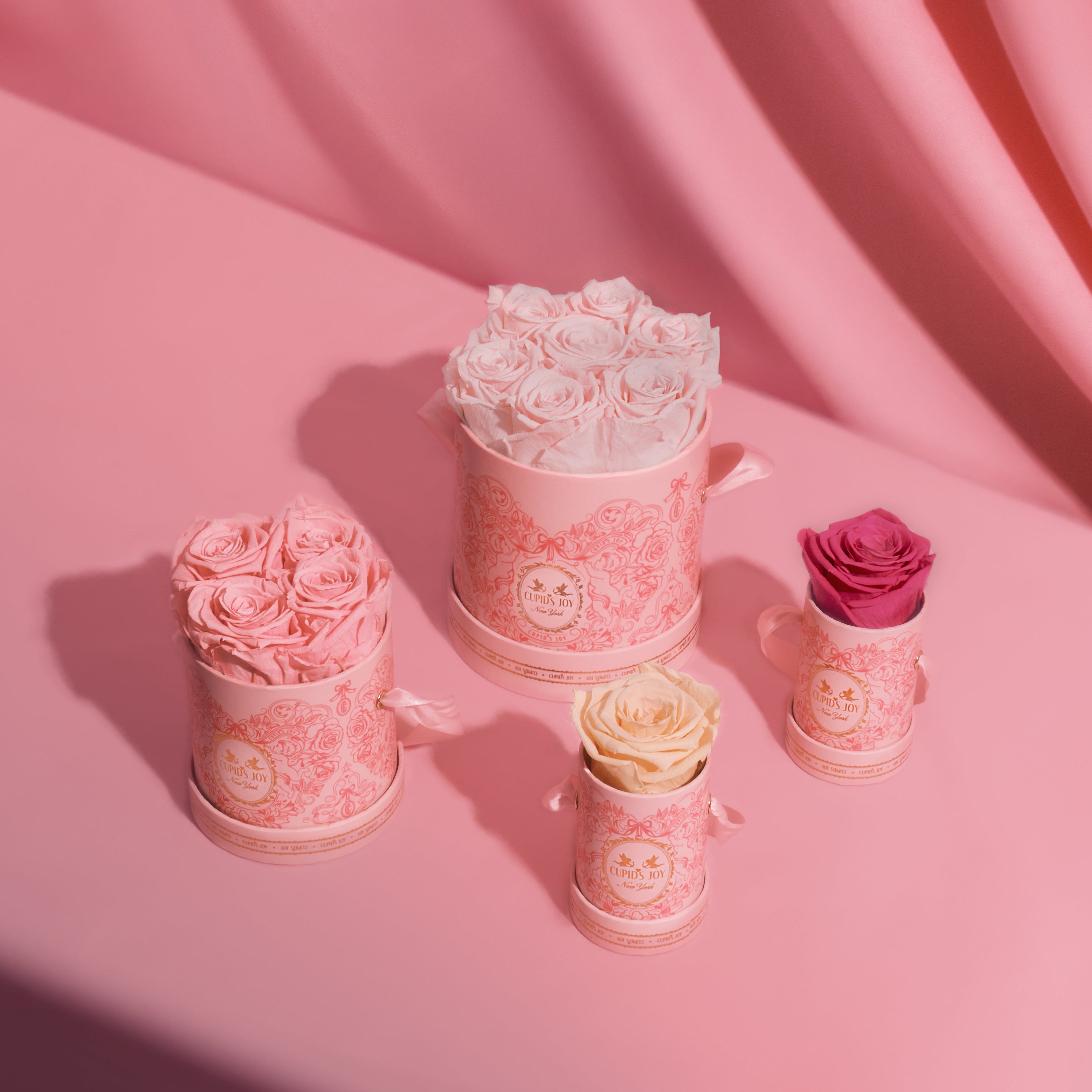 Styled display of preserved roses in luxury pink boxes from the Cupid's Joy collection by Maison Cupid
