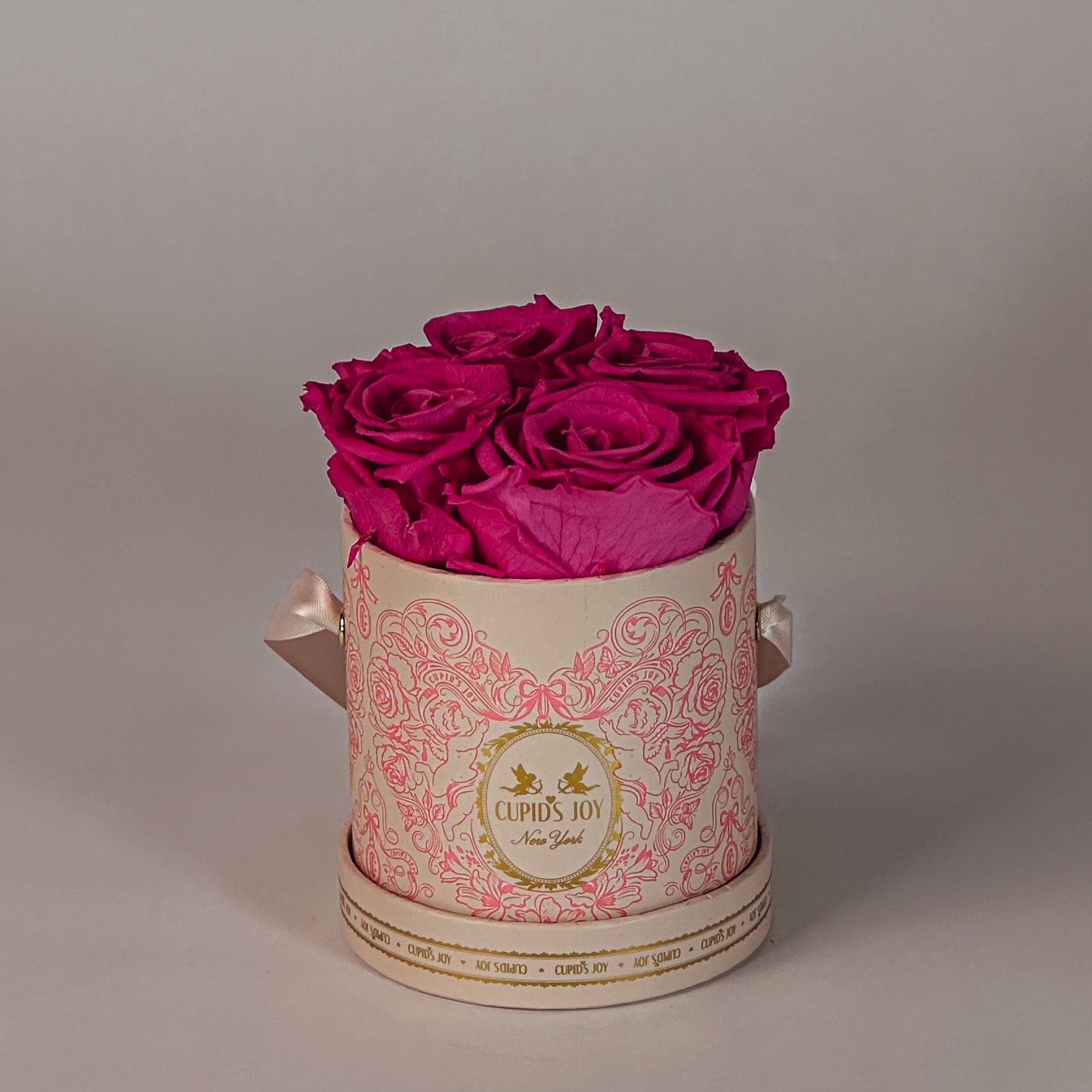 Small Cupid's Joy box with fuchsia roses on a neutral background